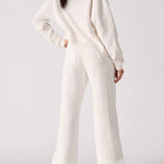 Rear view showing the clean fit of the white wide leg joggers.