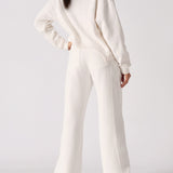 Rear view showing the clean fit of the white wide leg joggers.