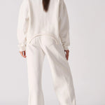 Back view of a model in white wide leg joggers and a matching top.