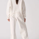 Back view of a model in white wide leg joggers and a matching top.