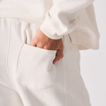 Detailed close up of the back pocket on white wide leg joggers.