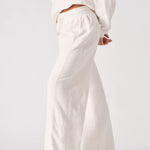 Side profile of a model wearing comfortable white wide leg joggers.