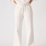Full body shot of a woman in premium white wide leg joggers.