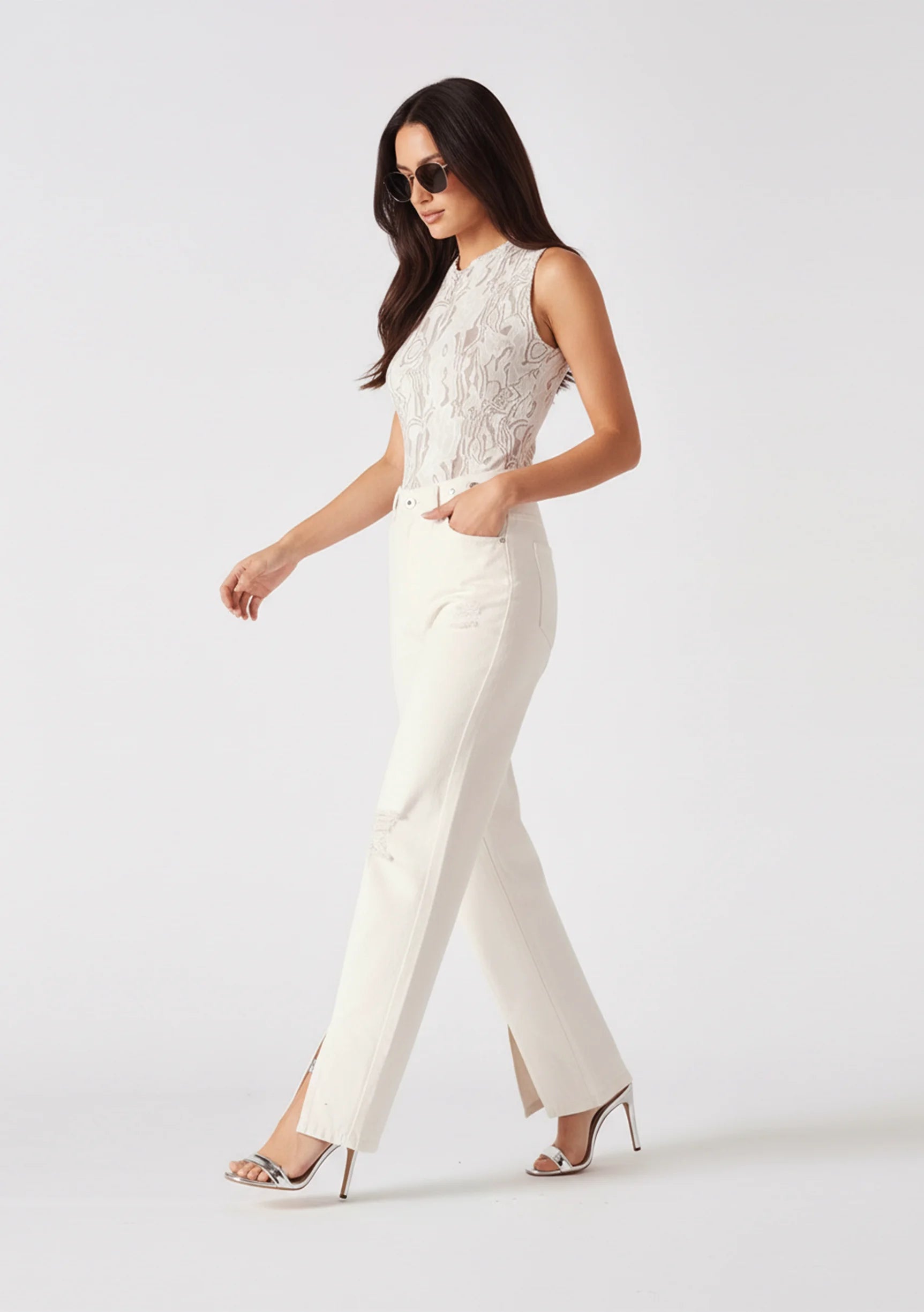 Model walking in white wide-leg trousers demonstrating the fabric drape and movement.