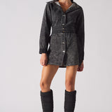 Model facing forward in the women's black acid wash denim dress, showing the full outfit