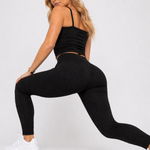 A woman in womens-black-bubble-texture-leggings performing a deep lunge back view showing the bubble texture detail and body skimming fit