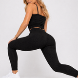 A woman in womens-black-bubble-texture-leggings performing a deep lunge back view showing the bubble texture detail and body skimming fit