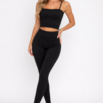 A woman wearing womens-black-bubble-texture-leggings with high waist styled with a matching black crop top and white trainers, front view