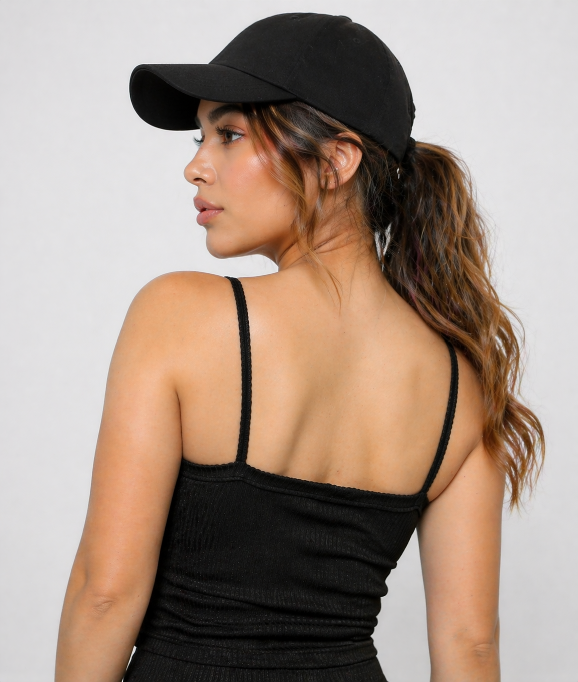 A woman wearing womens-black-ribbed-crop-top back view showing the thin straps and fitted cut