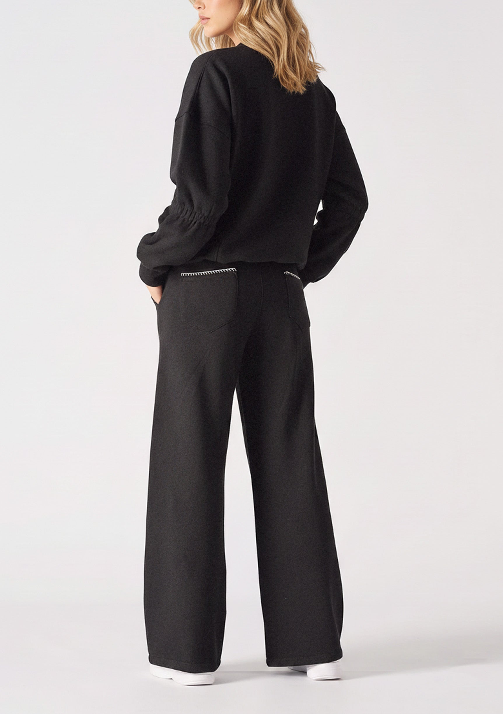 Rear view of a black crew neck jumper for women with relaxed shoulders