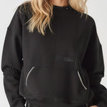 Close up front view of a black sweatshirt showing white contrast stitching