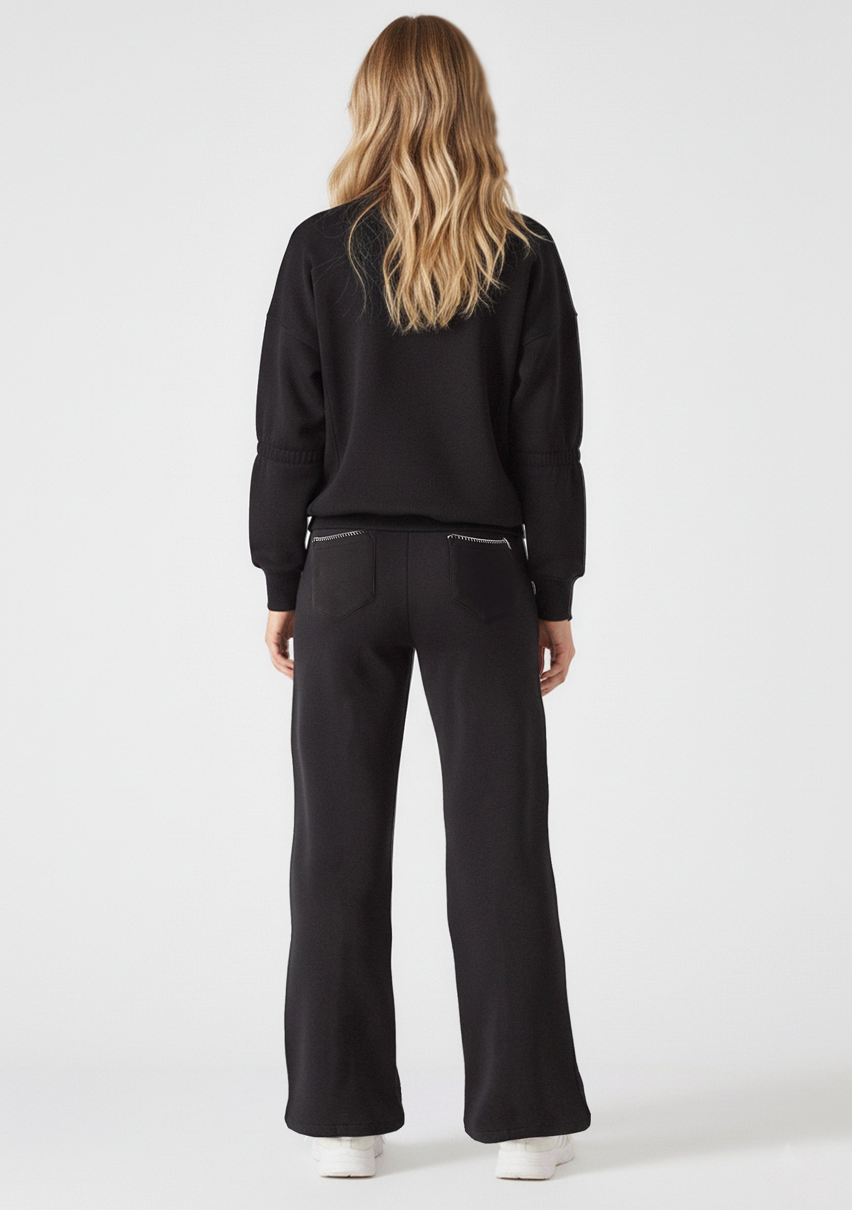 Full back view of a woman wearing a black sweatshirt and joggers set