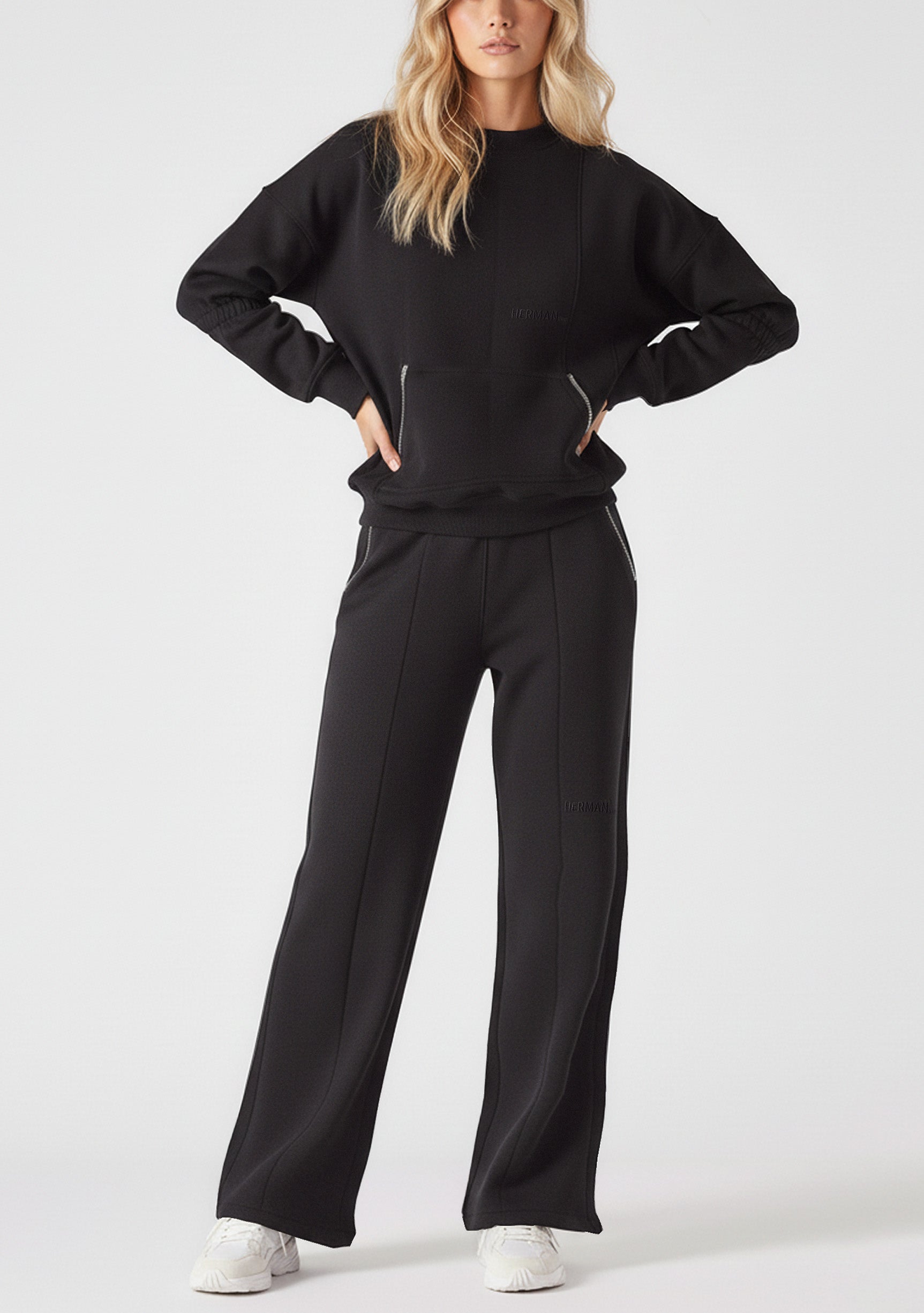 A woman posing in a comfortable black crew neck jumper with hands on hips