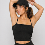 A woman wearing womens-black-ribbed-crop-top with arms raised showing the thin cami straps and natural support
