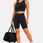 Model in black cycling shorts holding bag, casual outfit