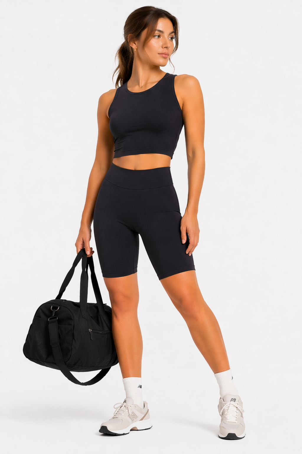Model in black cycling shorts holding bag, casual outfit