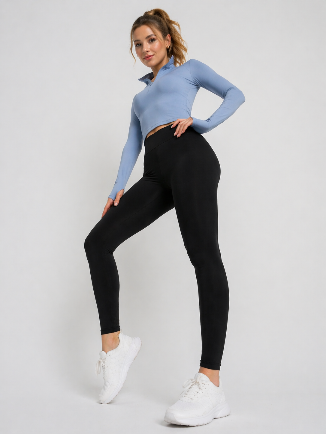 A woman wearing womens-black-high-waist-leggings standing side on, showing the deep waistband and full length leg fit