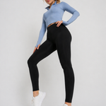 A woman wearing womens-black-high-waist-leggings standing side on, showing the deep waistband and full length leg fit