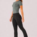 A woman wearing womens-black-kick-flare-leggings side view walking showing the fitted hip and full length flare hem