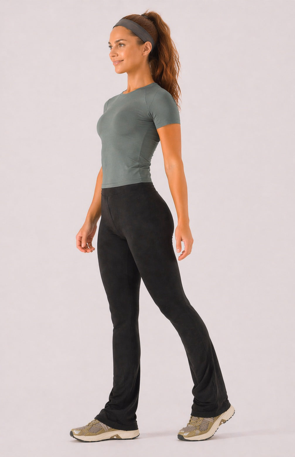 A woman wearing womens-black-kick-flare-leggings side view walking showing the fitted hip and full length flare hem