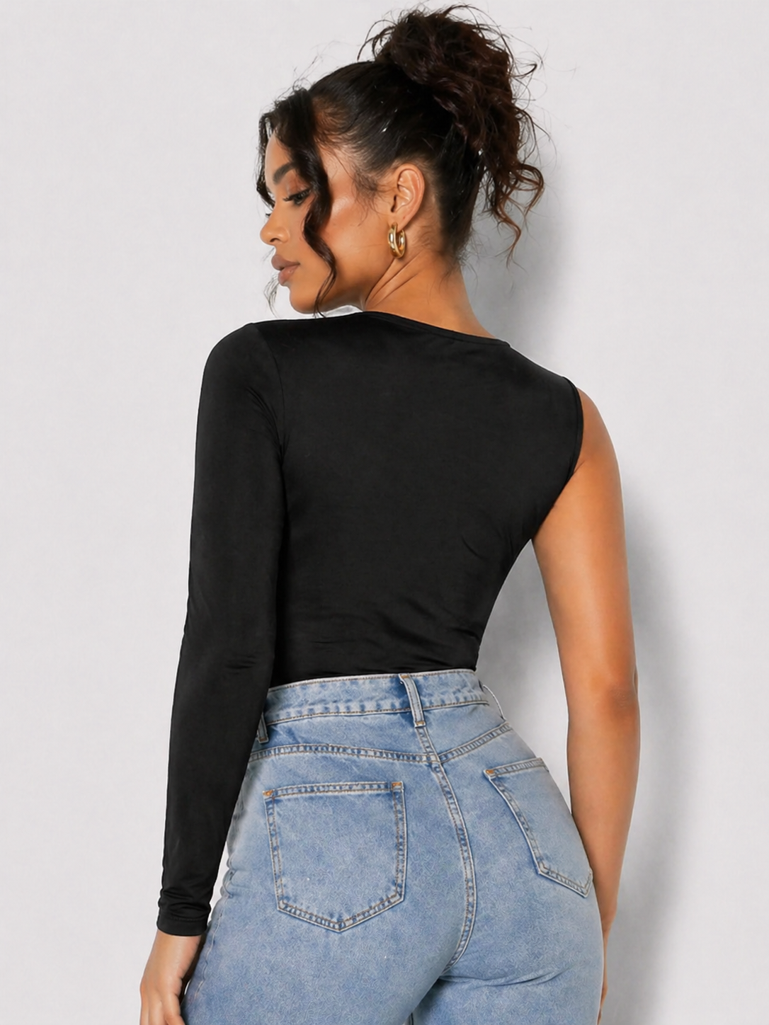 Back view of a woman wearing a Women's Black Ruched One Shoulder Asymmetric Bodysuit
