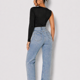 Full length back view of a woman in a Women's Black One Shoulder Long Sleeve Ruched Bodysuit with jeans