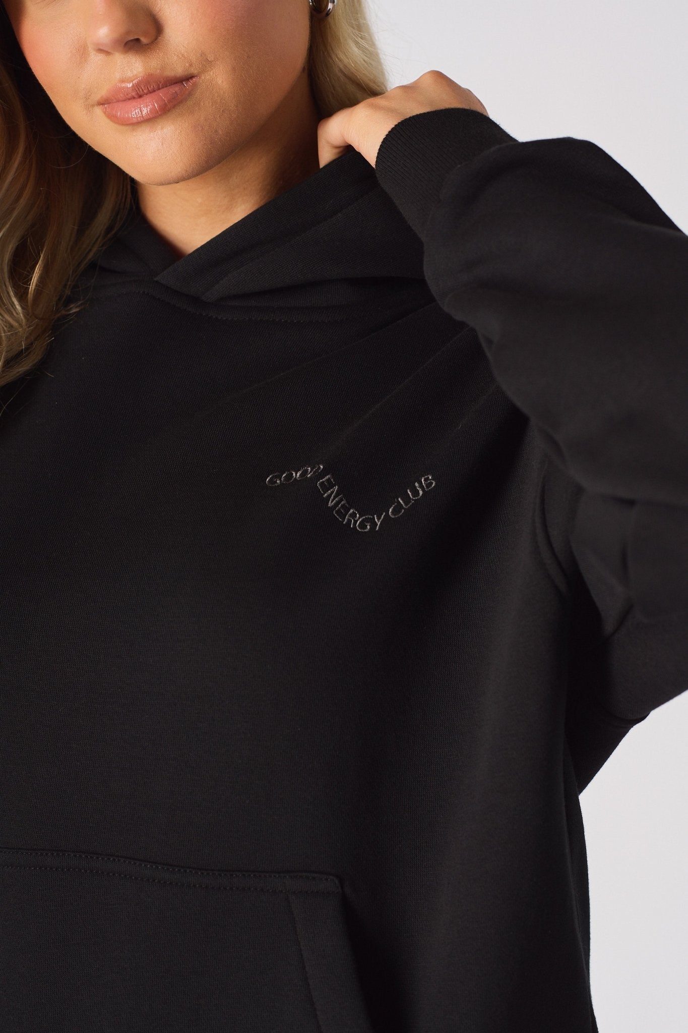 Detailed shot of the tonal embroidery on the chest of a black oversized hoodie