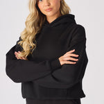 Close up shot of the dropped shoulder seam on a black oversized hoodie