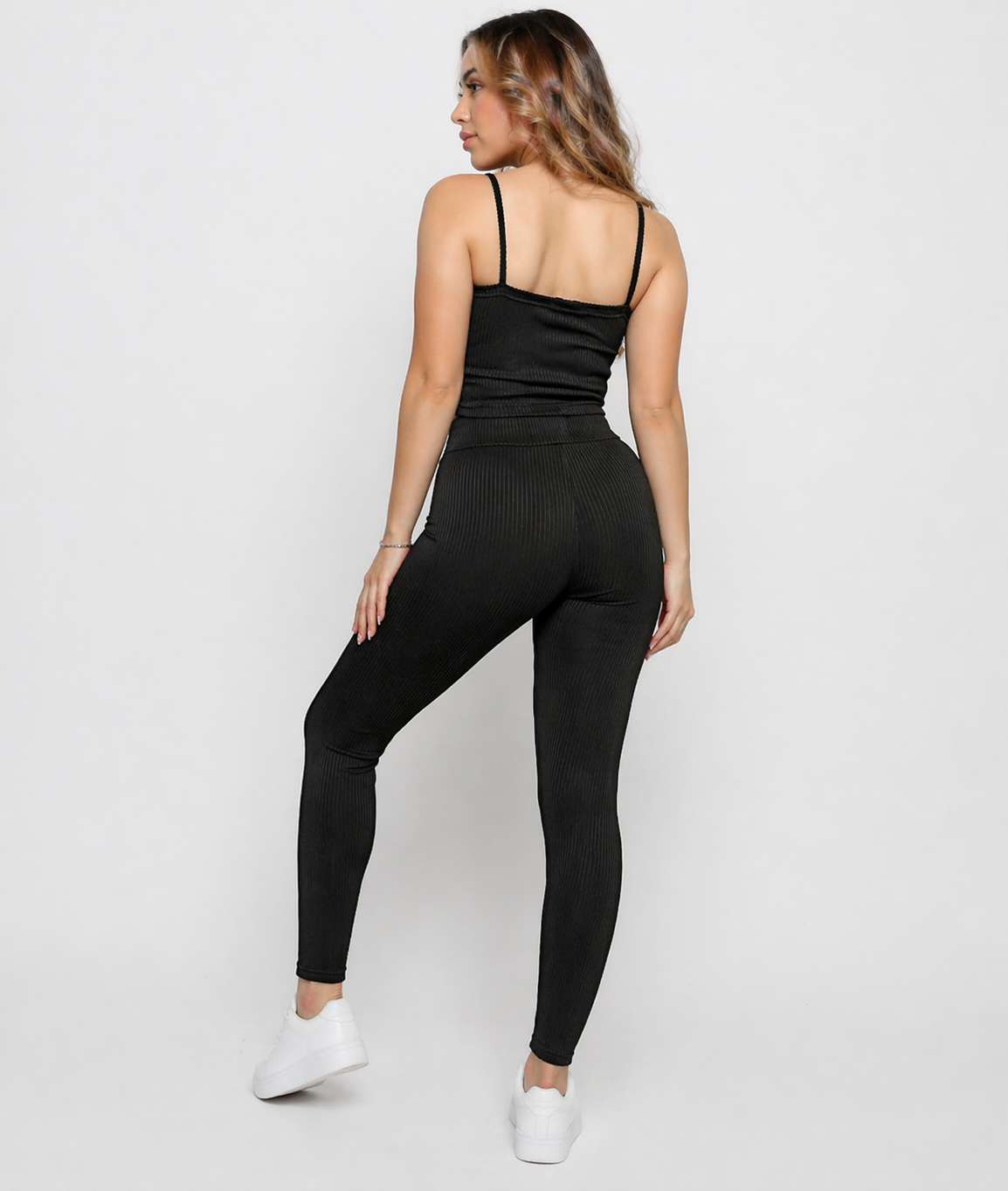 Back view of a woman wearing Women's Black Ribbed High Waist Leggings showing pintuck stripe leg detail