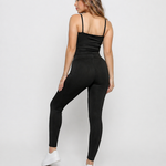 Back view of a woman wearing Women's Black Ribbed High Waist Leggings showing pintuck stripe leg detail