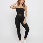 A woman standing wearing Women's Black Ribbed High Waist Leggings with matching cami crop top co-ord set full length view