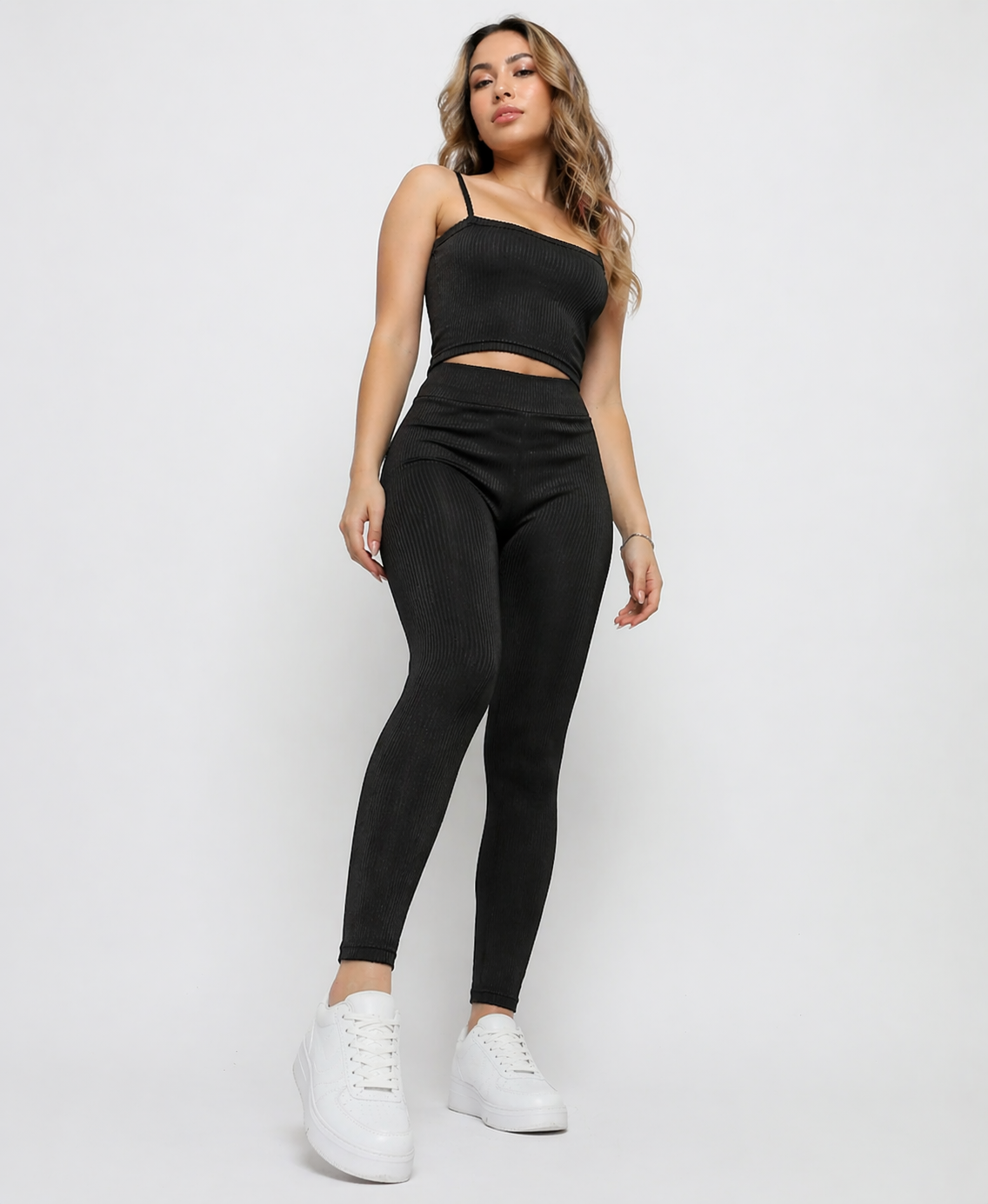 A woman standing wearing Women's Black Ribbed High Waist Leggings with co-ord cami crop top front view
