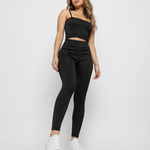 A woman standing wearing Women's Black Ribbed High Waist Leggings with co-ord cami crop top front view