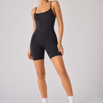A woman wearing womens-black-strappy-unitard full length front view styled with white socks and white trainers