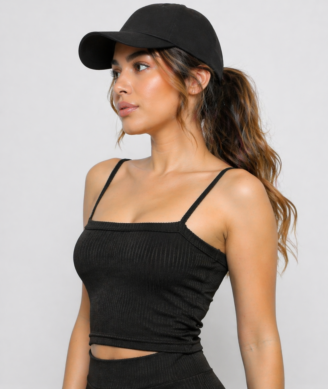 A woman wearing womens-black-ribbed-crop-top side view showing the fitted silhouette and ribbed texture detail