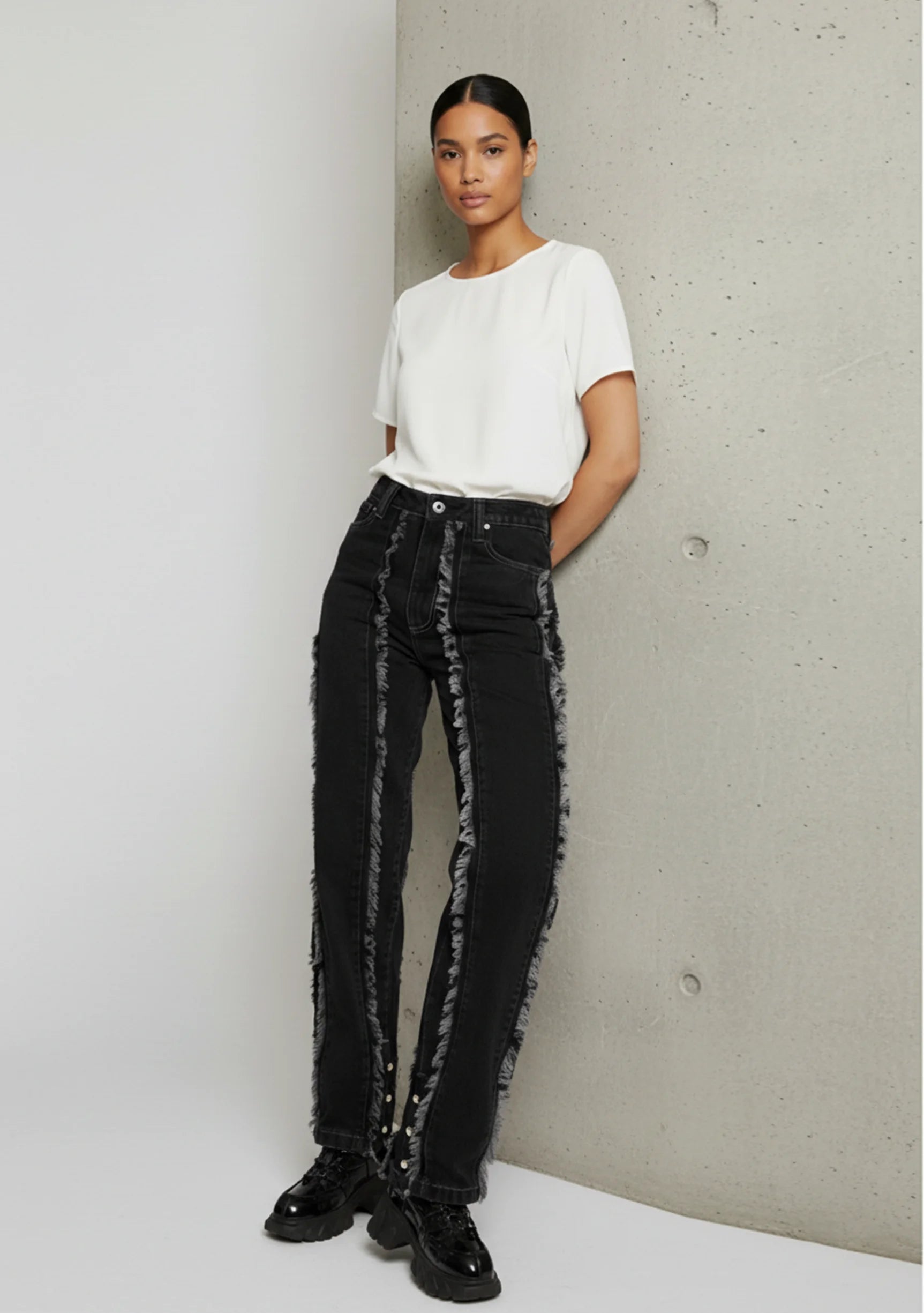 Lifestyle view of Womens Black Wash jeans leaning against wall