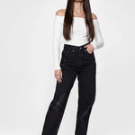 Front view of a model wearing Women's Black Wash Straight Leg Jeans with knee rips and ankle poppers