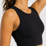 Side profile close-up of a women's black workout crop top showing the sleeveless racer neck fit.