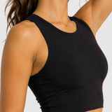 Side profile close-up of a women's black workout crop top showing the sleeveless racer neck fit.