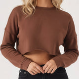 A close up shot of a brown cropped jumper for women featuring a crew neck and soft fabric