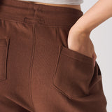 close up of back patch pocket and embroidery on brown tapered joggers