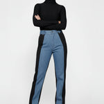 Side profile of a model walking in women's color block denim, emphasizing the straight leg silhouette.