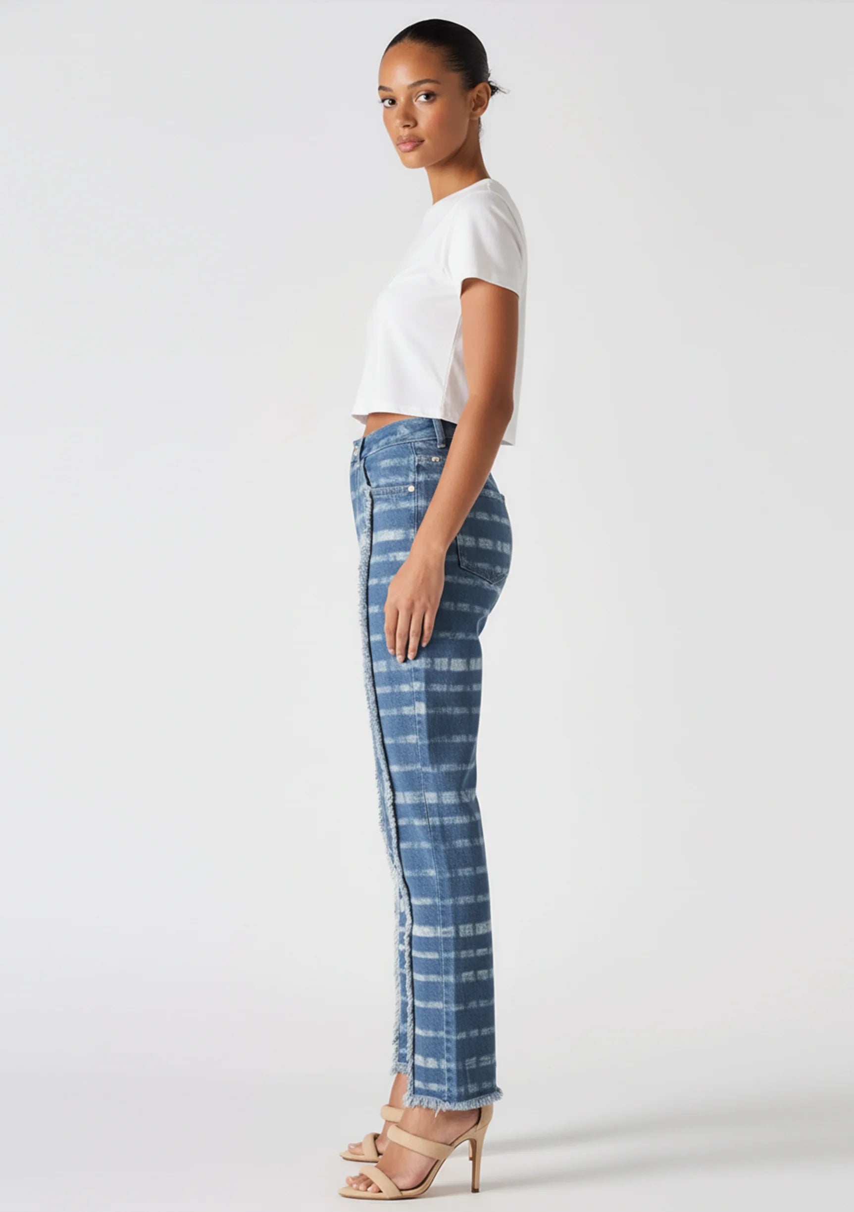 Side profile view of a model in Women's Distressed Edge Blue White Jeans