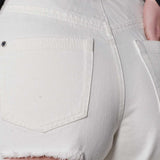 Detailed view of the rip and distressing under the back pocket of the jeans.
