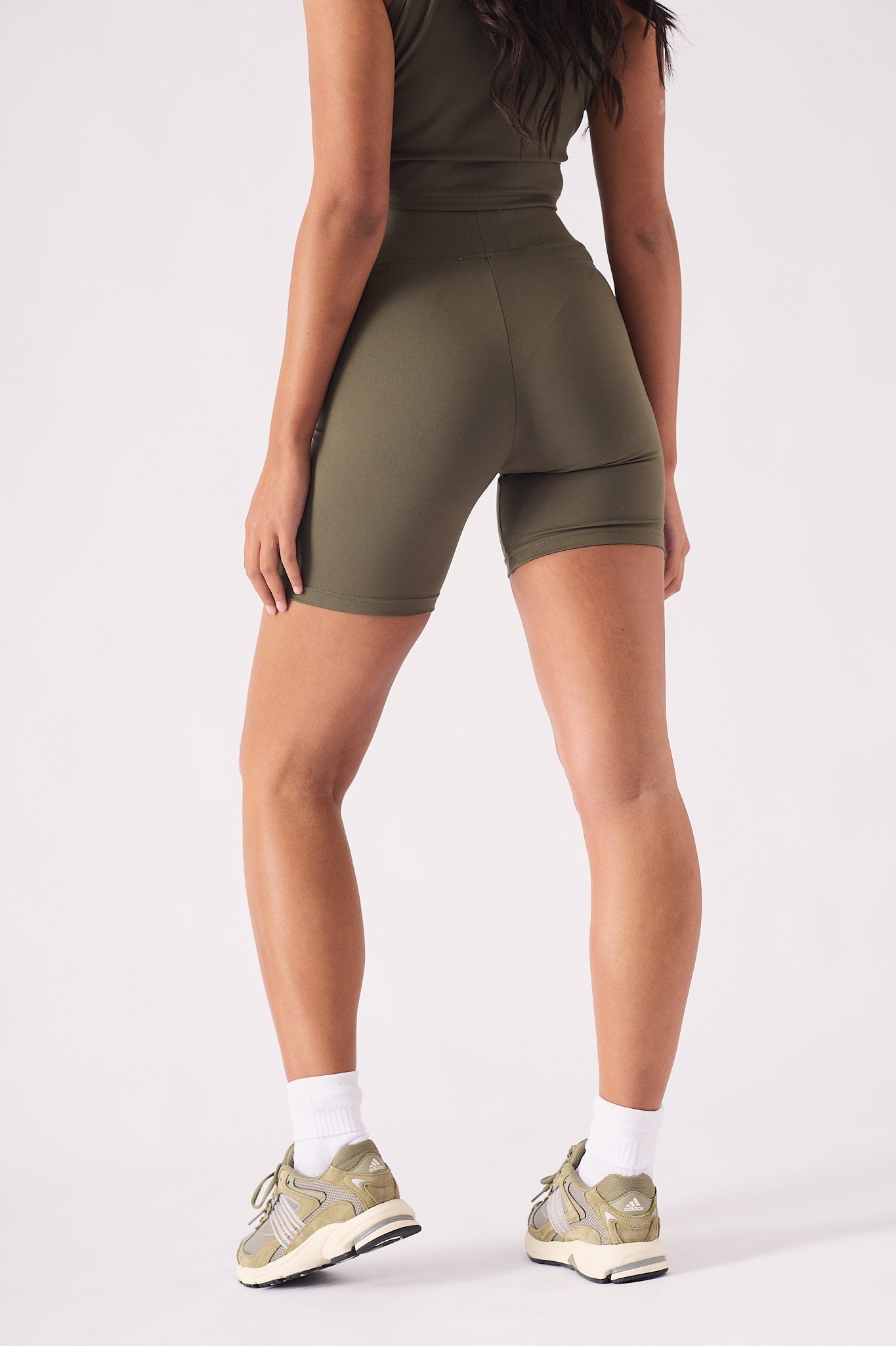 Rear view of a model in green cycling shorts showing the supportive second skin fit