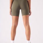 Close up rear view showing the high rise waistband of the green cycling shorts