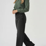 Full side length view of a woman styling a green half zip sweatshirt with black wide leg trousers