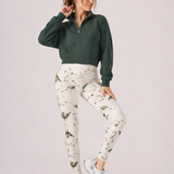 A woman wearing womens-green-stone-print-high-waist-leggings styled with a green half zip crop sweatshirt and white trainers, front view