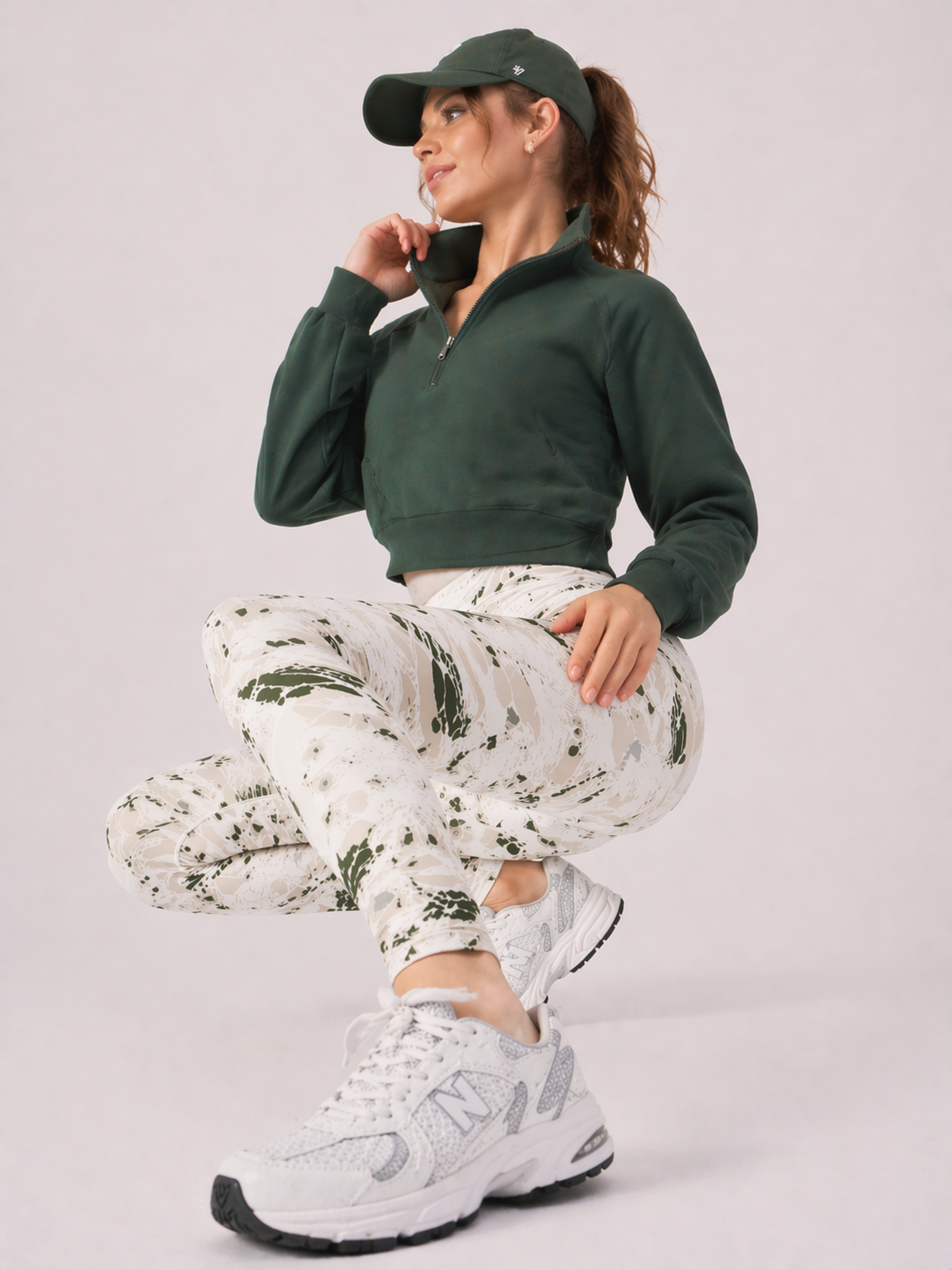 A woman in womens-green-stone-print-high-waist-leggings performing a squat showing full stretch and movement in the fabric