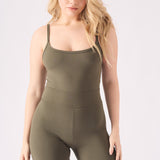 A mid length view of a woman posing in a comfortable green unitard